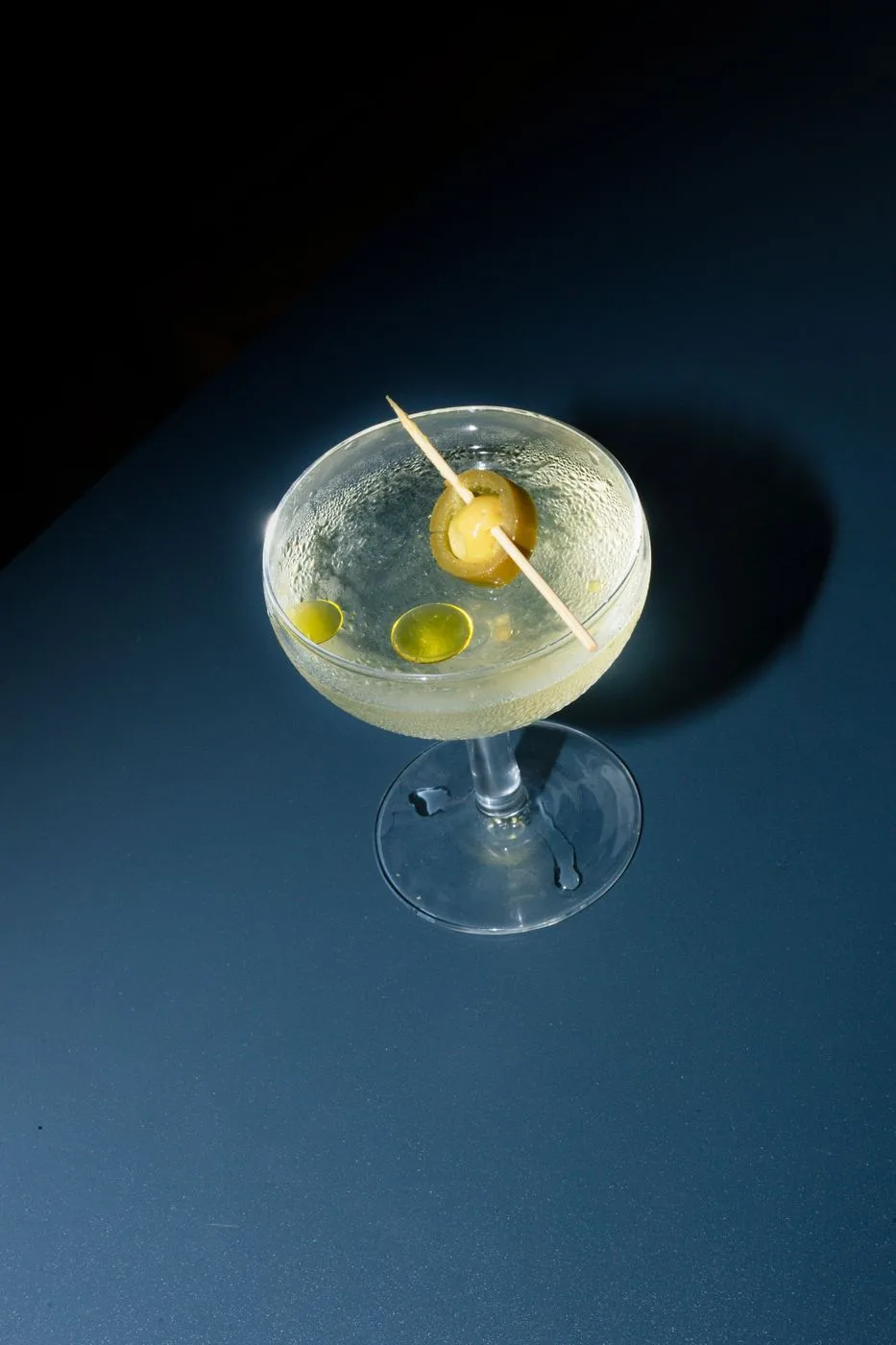 Metl — martini fotografiado sobre mesa oscura